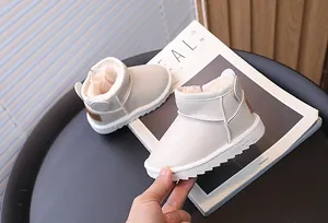 Dettaglio di caldi scarponi da neve per bambini color crema con fodera in peluche.