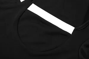 Détail de la combinaison en maille noire avec col bas et bordure blanche