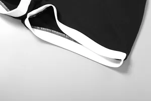 Gros plan sur la bordure contrastée blanche et les coutures de la combinaison noire en maille
