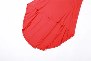 Detalle del dobladillo asimétrico rojo vibrante en un vestido entallado moderno