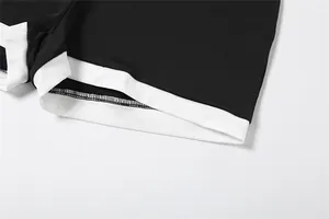 Vue détaillée de l'ourlet blanc contrasté et des coutures sur un combishort en maille noire.
