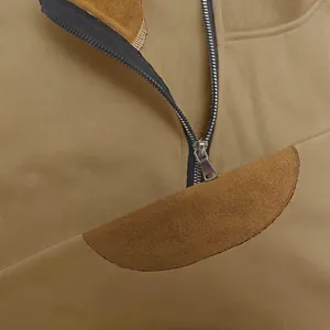 Primo piano di una felpa in pile da uomo con mezza zip e dettaglio patch testurizzato