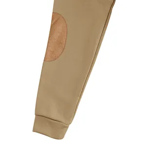 Dettaglio della manica della felpa kaki con toppa marrone scamosciata e polsino.