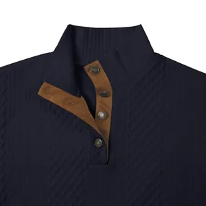 Detalle de la sudadera azul marino con textura de diamantes y cuello con botones.