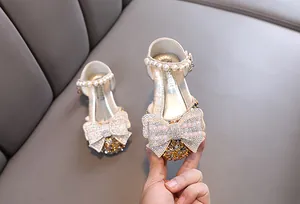 Detailansicht der glitzernden Strass-Schleife an Mädchen-Prinzessinnen-Leder-Tanzschuhen