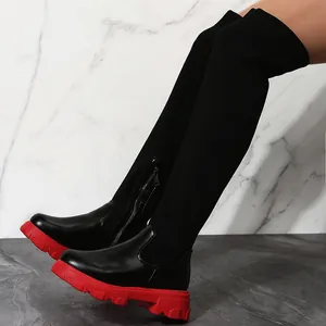Vue détaillée de bottes noires en maille au-dessus du genou avec semelles rouges.