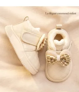 Detailed view of beige toddler winter boots with plaid bow and plush lining