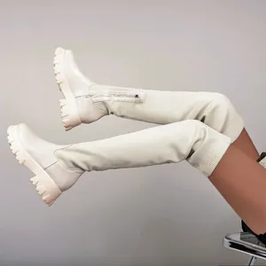 Détail de bottes cuissardes crème avec semelle compensée et tissu en maille stretch
