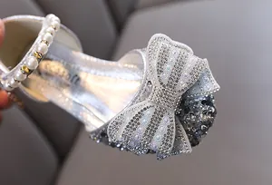 Detailansicht der silbernen Glitzer-Prinzessinenschuhe mit Paillettenschleife und Perlenband