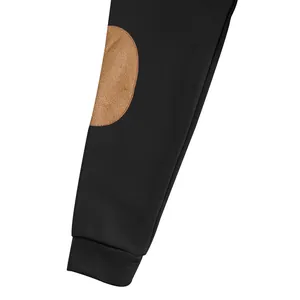 Dettaglio della manica di una felpa nera con toppa sui gomiti in camoscio beige e polsino