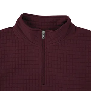 Detalle de sudadera granate para hombre con media cremallera y textura de cuadros acolchados