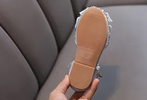 Nahaufnahme der rutschfesten Gummisohle von silbernen Prinzessinnenschuhen für kleine Mädchen