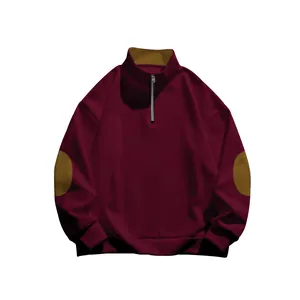 Dettaglio pullover bordeaux con mezza zip, toppe marroni sui gomiti e colletto alla coreana.