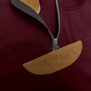 Dettaglio ravvicinato di una felpa in pile bordeaux con mezza zip e collo alto.