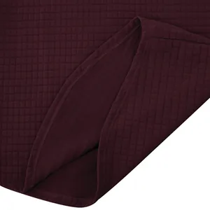 Detalle de sudadera granate para hombre que muestra la textura de tela acolchada de cuadros