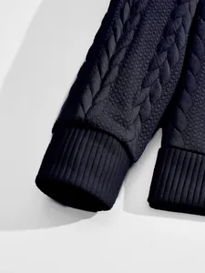 Detail view of the heavy jacquard fabric and ribbed cuffs on the men's shirt