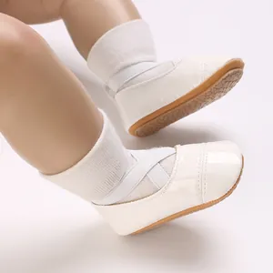 Vue détaillée des chaussures de princesse bébé en cuir verni blanc avec sangles croisées