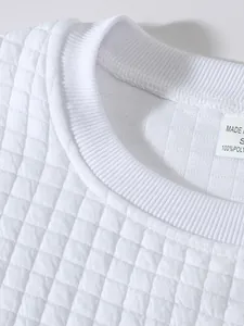Nahaufnahme eines weißen Sweatshirts mit gesteppter Karotextur und geripptem Ausschnitt.