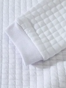 Makroansicht eines weißen gesteppten Sweatshirt-Ärmels mit Premium-Rippbündchen