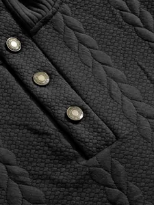 Macro detail of heavy jacquard fabric and metal buttons on men's sweatshirt.