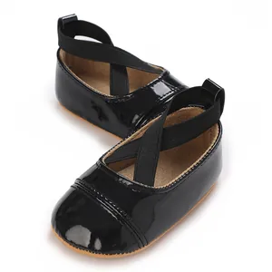 Vue détaillée de chaussures de bébé fille en cuir verni noir avec brides croisées