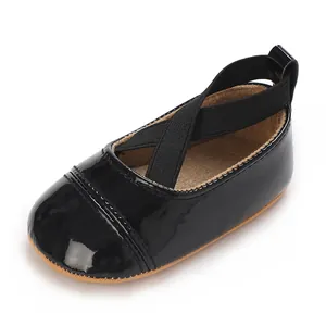 Vue détaillée des chaussures en cuir verni noir pour bébé fille avec bride croisée.