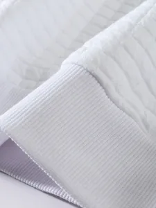 Nahaufnahme des weißen Sweatshirt-Ärmels mit Rippbündchen und gesteppter Textur