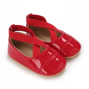 Détail de chaussures de princesse pour bébé en cuir verni rouge avec brides croisées