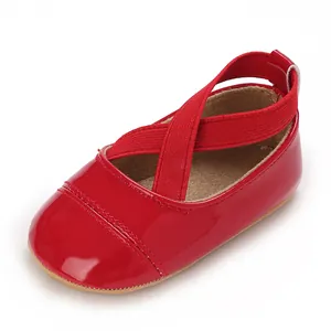 Gros plan détaillé de chaussures de bébé en cuir verni rouge avec brides croisées