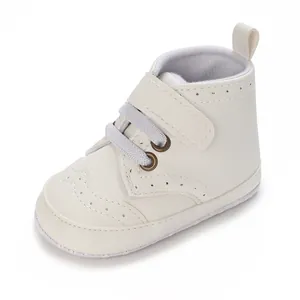 Détail de chaussures de marche pour bébé à semelle souple crème avec bande velcro.