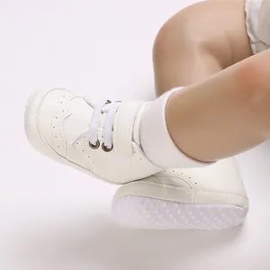 Gros plan de chaussures de marche souples blanches pour bébé avec broderies fines