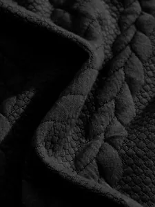 Macro close-up detail of heavy black jacquard fabric texture for men's Henley shirt