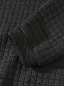 Detailaufnahme der hochwertigen schwarzen Steppstruktur und des Rippbündchens eines Sweatshirts