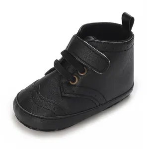 Gros plan de chaussures de marche pour bébé noires à semelle souple et scratch