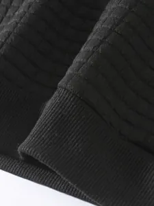 Nahaufnahme des schwarzen Herren-Sweatshirts mit Rippbündchen und Gitterstruktur