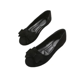Nahaufnahme schwarzer Wildleder-Ballerinas mit großer Schleife und runder Spitze