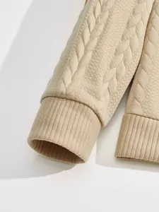 Close-up of ribbed cuffs on a beige men's heavyweight jacquard textured sweatshirt