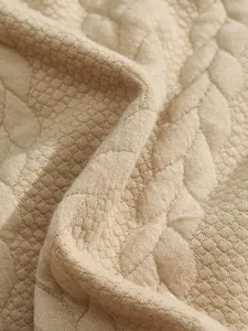 Detailed close-up showing the heavy jacquard texture on a beige men's long sleeve sweatshirt