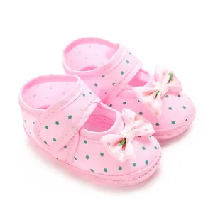 High-resolution detail shot of pink polka dot baby pre-walker shoes with cute bows