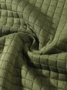 Nahaufnahme des hochwertigen olivgrünen Waffelstrickstoffs mit strukturiertem Karomuster