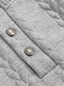 Close-up detail of heavy jacquard fabric and metal snap buttons on grey men's sweatshirt