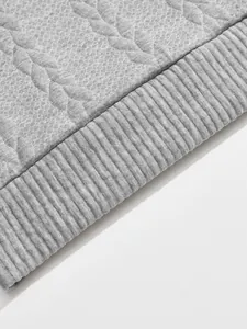 Macro detail view of grey jacquard knit texture and ribbed hem on a heavyweight sweatshirt