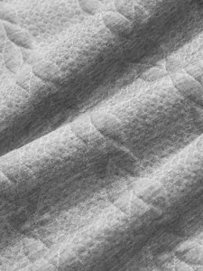 Detailed macro shot of grey jacquard quilted fabric for men's heavy casual sweatshirt