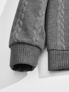 Detail of grey men's sweatshirt featuring heavyweight jacquard texture and ribbed cuffs.