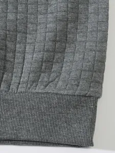 Makrodetail eines grauen Herren-Sweatshirts mit Karomuster und Rippbündchen am Ärmel.