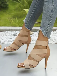 Detail view of apricot high heel sandals with elastic crisscross straps and back zipper.