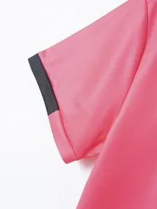 Detailaufnahme eines rosa Poloshirts mit schwarzem Kontrastbündchen und feinen Nähten