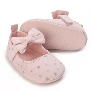 Primer plano de zapatos rosa para bebé con estrellas plateadas y lazo