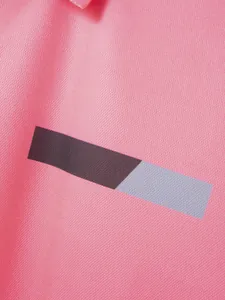 Makro-Detail von rosa Polo-Shirt-Stoff mit schwarz-grauem geometrischem Brustdruck