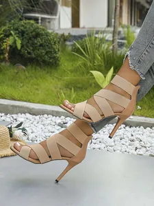 Detailed view of nude high-heeled sandals with elastic cross straps and back zipper